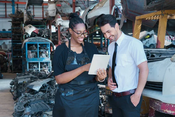 Woman work with man. Diversity of two people, black African worker woman using tablet with caucasian business manager in factory-warehouse