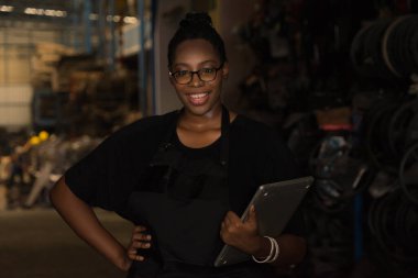 Çalışmaktan mutlu olan kadın, dizüstü bilgisayarını tut. Siyah Afrikalı kadın fabrika deposunda çalışmaktan mutlu.