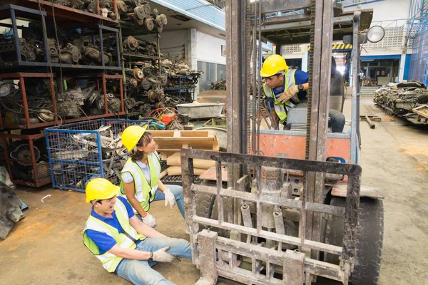 Geniş açıda çalışan bir işçinin kaza geçirmesi, makinistin bacağının üzerinde forklift. Mühendis kadın fabrika deposunda adamla konuşurken forkliftle ezilmekten acı çeken Asyalı mühendis.