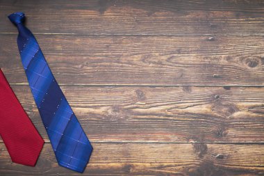 Represent scene of two tie gifts for dad at left side with dark wood background. Background scene of child gives happy gift to father in father's day concept