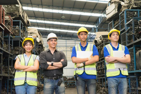 Man and woman work together, diversity of medium shot of Caucasian and Asian engineer worker men and woman stand and crossed arms  in factory-warehouse