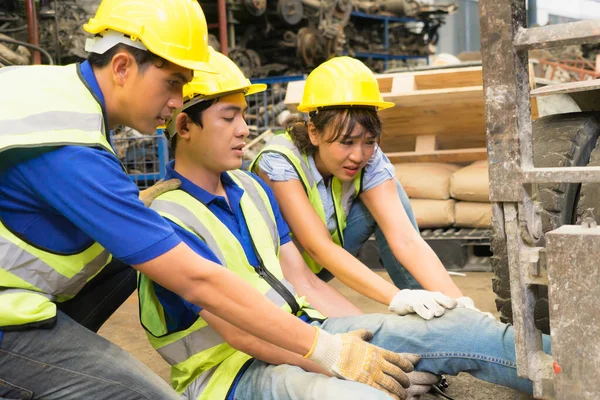 Accident of working man, forklift over leg of engineer. Asian engineer worker man was crushed by a forklift and engineer woman and man helping him in factory-warehouse