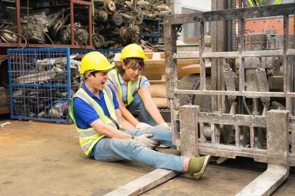 Geniş açıda çalışan bir işçinin kaza geçirmesi, makinistin bacağının üzerinde forklift. Asyalı mühendis, fabrika deposunda ona yardım eden bir forklift ve mühendis kadın tarafından ezildi.