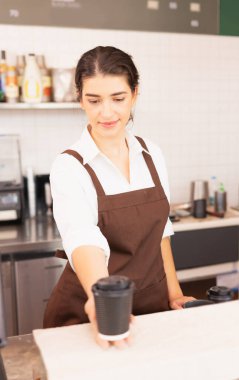 Kafkasyalı güzel bir kadının dikey çerçevesinde bir elinde kahve fincanı, diğer elinde de kahve fincanı var. Kahve barında ve yemek servisinde çalışıyor.