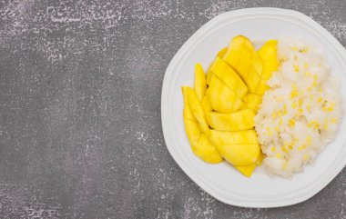 Çerçevenin sağ tarafı - Tabakta mangolu Tayland pilavı ve taş kaplama arka plan, Yapışkan pirinç, mango ve hindistan cevizinden yapılan tatlı Thai tatlı mutfağı