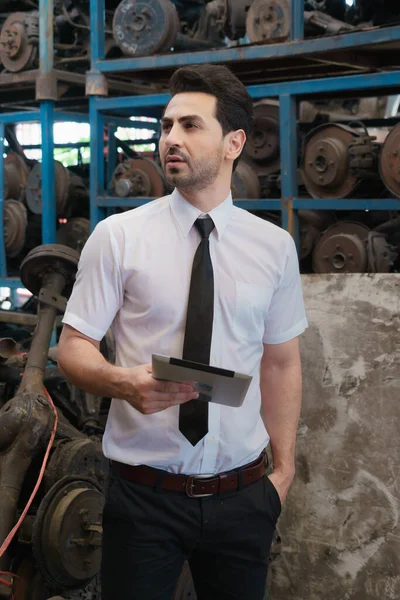 Smart man looking product, right side. Caucasian business manager looking right side to product in factory-warehouse