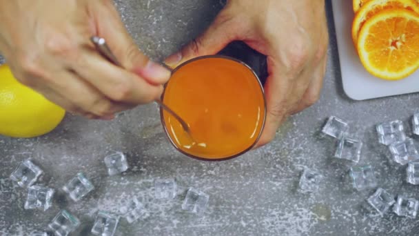新鮮なオレンジ テーブルの上の氷 バーテンダーはバーでパーティーで飲むためのフルーツカクテルや新鮮なジュースを準備します — ストック動画