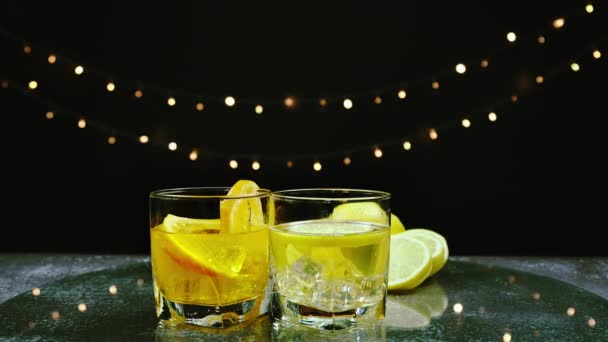 オレンジジュースとレモンジュースをグラスにスライスしたオレンジとレモンを応援する バーテンダーはバーでパーティーで飲むためのフルーツカクテルやフレッシュジュースを準備します — ストック動画