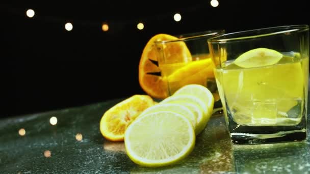 新鮮なオレンジ スライスレモン テーブルの上のジュースグラスの揺れカメラショット バーテンダーはバーでパーティーで飲むためのフルーツカクテルや新鮮なジュースを準備します — ストック動画