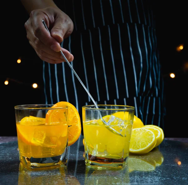 Mann Rührt Eis Und Zitronensaft Glas Neben Orangensaftglas Auf Tisch — Stockfoto