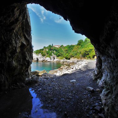 Beautiful sea , trees, and sand view thru a cave 