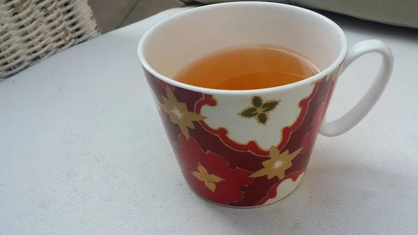 Egy Csésze Tea Egy Asztalon Rózsaszín Virágokkal Ülő Figura Fogalmak — Stock Fotó