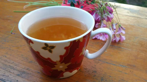 Egy Csésze Tea Egy Asztalon Rózsaszín Virágokkal Ülő Figura Fogalmak — Stock Fotó