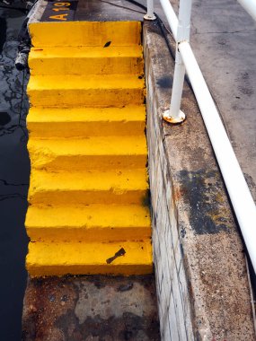 Yunanistan 'ın limanındaki bir rıhtımda sarı boyalı beton basamaklar