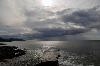 Gerolimenas, Mani, Moreloponnese, Yunanistan 'daki küçük taşlı iskele, gri, yağmurlu ve tehditkar kış gökyüzünün altında