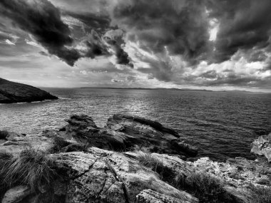 Cyclades 'teki Kea Adası' nın kayalık kıyı şeridi boyunca çekilmiş yüksek kontrastlı tek renkli kıyı manzaraları koleksiyonu. Karanlık, hızlı hareket eden kümülonimbus ve stratocumulus bulutları dokulu Ege Denizi 'nin üzerindeki gökyüzüne hakim olurken engebeli uçurumlar...