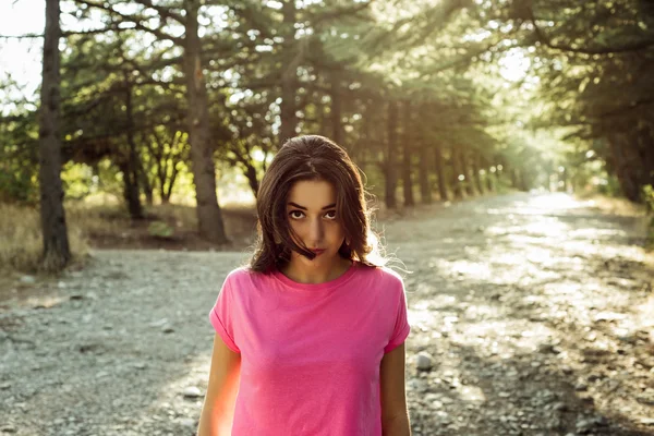 Retrato de bela jovem mulher em contra o fundo do sol — Fotografia de Stock