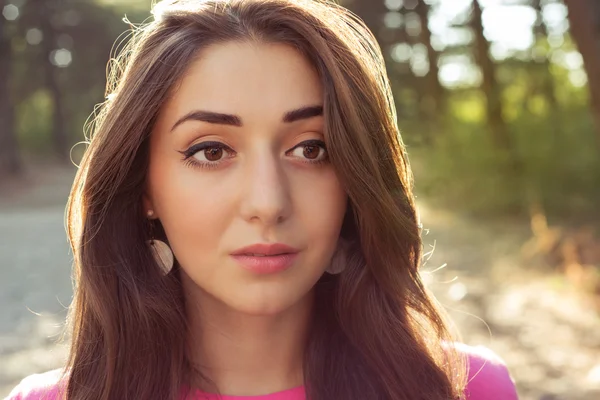 Portrait of beautiful young woman against the sun — Stock Photo, Image