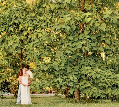 Mutlu hamile çift banch parkta oturan