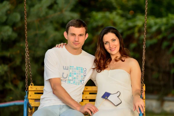 Boldog terhes pár ül a parkban termékeinek — Stock Fotó