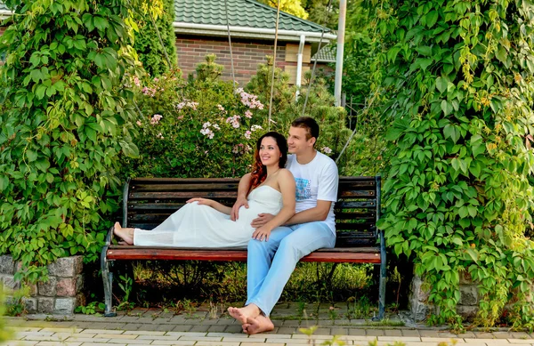 快乐怀孕的夫妻坐在公园里下属 — 图库照片
