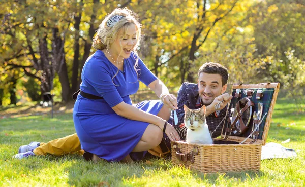 Terhes boldog és mosolyog pár piknik a macska — Stock Fotó