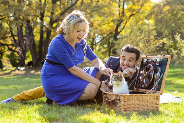 Terhes boldog és mosolyog pár piknik a macska — Stock Fotó