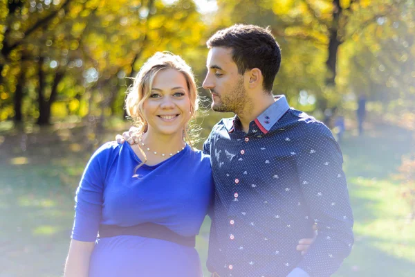 Felice e giovane coppia incinta abbracci in natura — Foto Stock