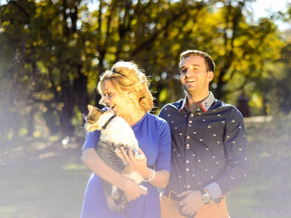 Feliz e jovem casal grávida abraçando na natureza — Fotografia de Stock