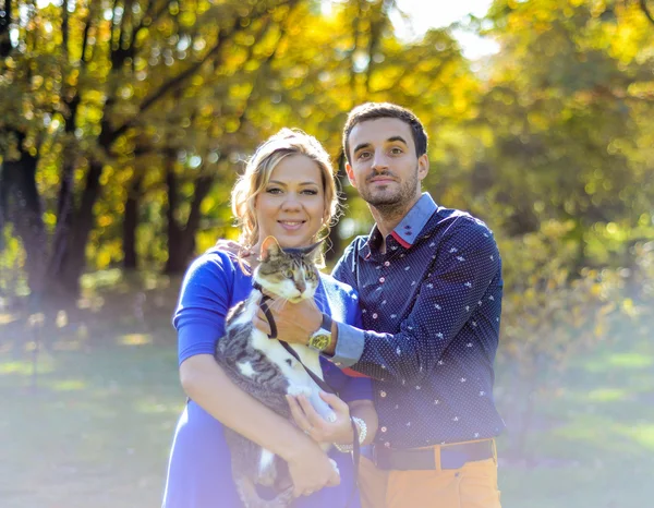 Счастливая и молодая беременная пара, обнимающаяся на природе — стоковое фото
