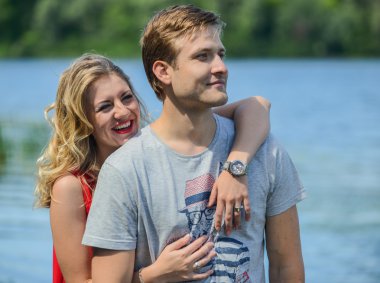 Genç mutlu çifte sarılma ve nehir arka plan üzerinde gülüyor