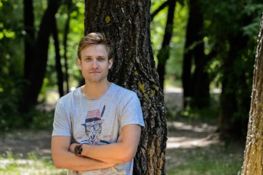 parkta poz T-shirt giyen genç adam