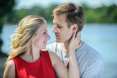 Genç mutlu çifte sarılma ve nehir arka plan üzerinde gülüyor