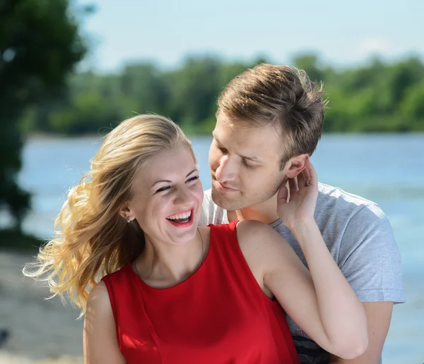 Unga lyckliga par kramar och skratt på floden bakgrund — Stockfoto