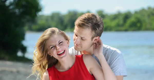 Young happy couple hugging and laughing on river background — Stock Photo, Image