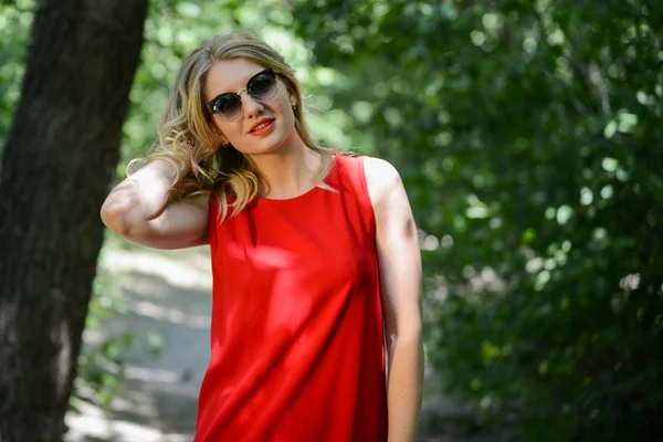 Krásná mladá žena v slunečních brýlí v blízkosti letní park — Stock fotografie