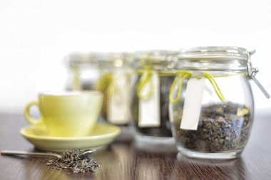 kaşık, cam kavanoz ve beyaz arka plan ile ahşap masa bardakta çay