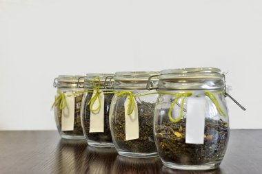 Beyaz arka plan ile ahşap tabloda çay cam kavanozlar