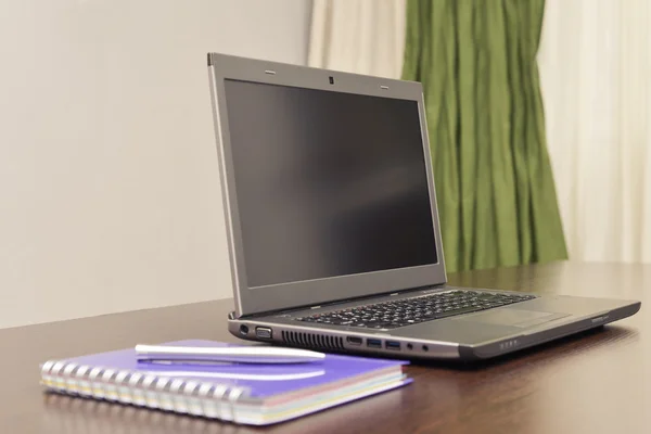 Laptop książkę adresową i pióra na stole. — Zdjęcie stockowe