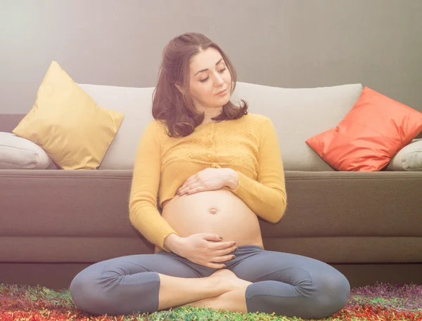 Krásná zdravá těhotná žena sedí na koberci — Stock fotografie