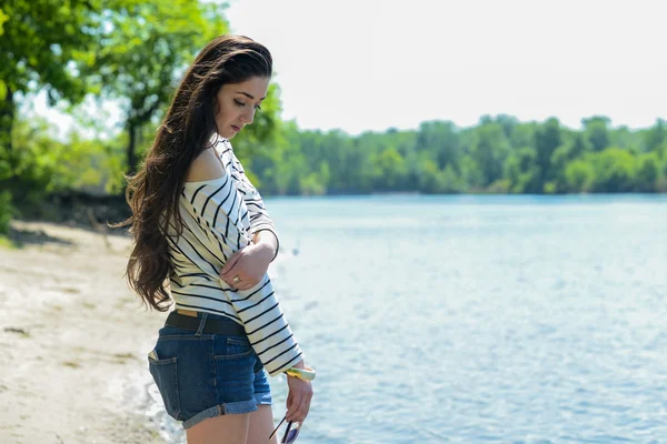 Pretty girl on the beach look at water — Stock Photo, Image