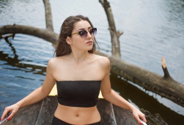 Teknede oturan gözlüklü kız