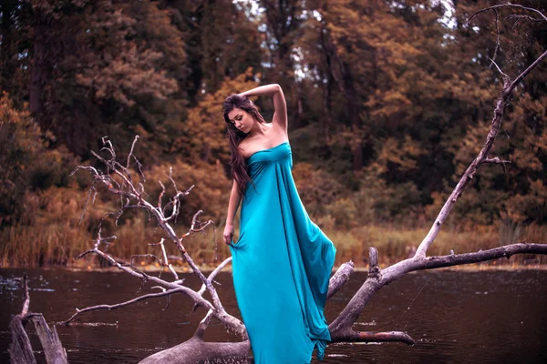 Mädchen mit Kleid steht in Fluss in Waldnähe — Stockfoto