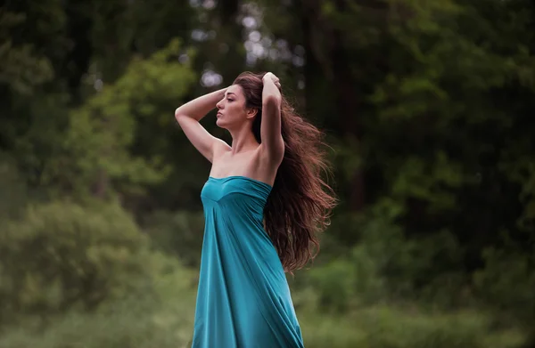 Girl in dress standing with forest background — Stock Photo, Image