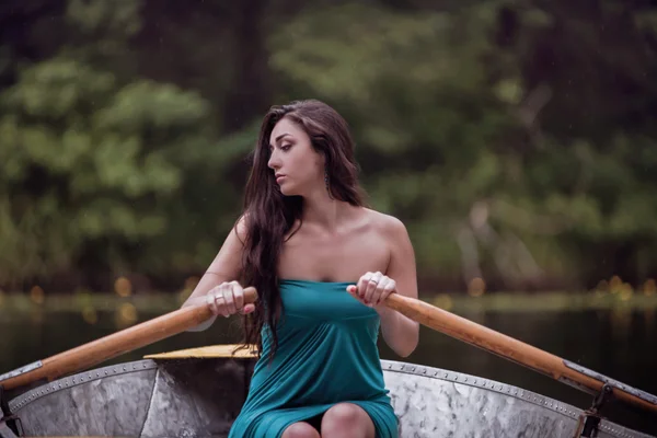 Lange Haare brünett in einem Kleid auf dem Boot sitzend — Stockfoto