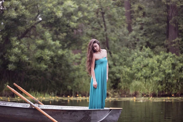 Long hair brunette in a dress standing on the boat — Stock Photo, Image