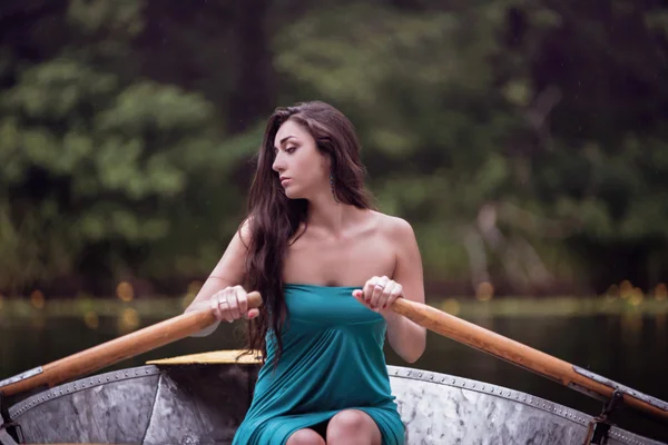 Lange Haare brünett in einem Kleid auf dem Boot sitzend — Stockfoto