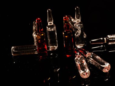 Tıbbi ampuller kapanıyor. Bir sürü ampul. Masada cam ampuller var. İlaç ile dağılmış ampuller.