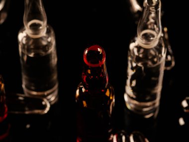 Tıbbi ampuller kapanıyor. Bir sürü ampul. Masada cam ampuller var. İlaç ile dağılmış ampuller.