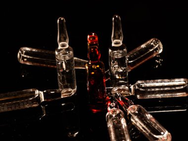 Tıbbi ampuller kapanıyor. Bir sürü ampul. Masada cam ampuller var. İlaç ile dağılmış ampuller.